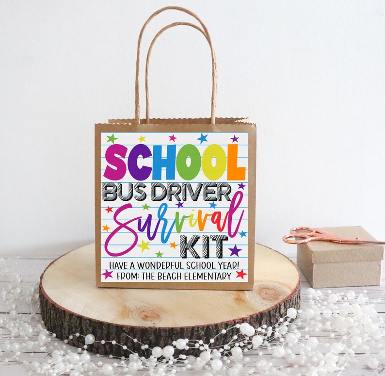 K&ouml;nnte beinhalten: Eine braune Papiert&uuml;te mit einem bunten bedruckten Etikett, auf dem "School Bus Driver Survival Kit" und "Have a Wonderful School Year! From: The Beach Elementary" steht.