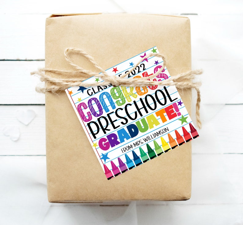 K&ouml;nnte beinhalten: Ein farbenfroher Geschenkanh&auml;nger mit dem Text "Class of 2022 Congrats Preschool Graduate!" und einer Reihe bunter Stifte unten. Der Text "From: Mrs. Williamson" befindet sich unten auf dem Anh&auml;nger.