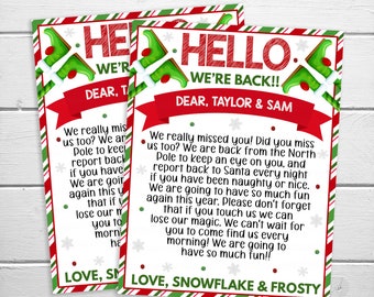 Op de afbeelding: Twee kerstkaarten met rood-groene randen. De kaarten luiden "HELLO WE'RE BACK!!" en bevatten een bericht aan "TAYLOR & SAM" van "SNOWFLAKE & FROSTY". De kaarten hebben een feestelijk ontwerp met sneeuwvlokken en elf-afbeeldingen.
