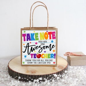 May include: A brown paper gift bag with a colorful printed tag that says "Take Note You Are One Awesome Teacher! Thank You For All You Do! From: The Lakeside PTO".