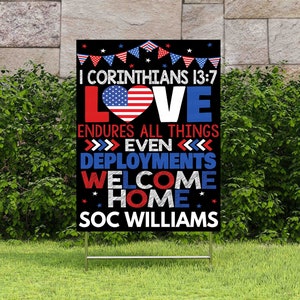 May include: A black and white welcome home sign with red, white, and blue accents. The sign features the text "I Corinthians 13:7 Love Endures All Things >>>> Even <<<<<<< Deployments Welcome Home SOC WILLIAMS".