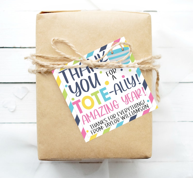 May include: A colourful gift tag with the text "Thank you for a tote-ally amazing year!" and "Thanks for everything! From: Taylor Williamson". The tag is tied with twine to a brown gift box.