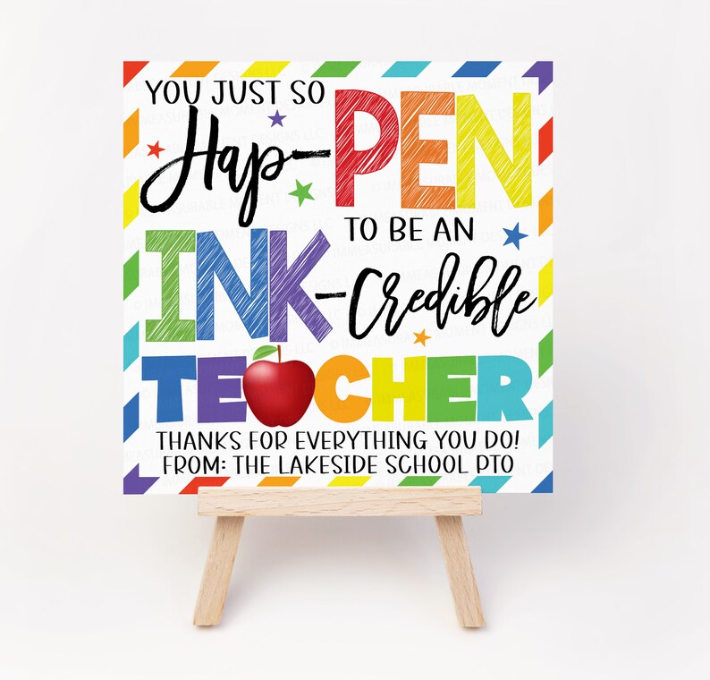 May include: A colourful sign with the text "You just so Hap-PEN to be an INK-Credible TEACHER" with a red apple and stars. The sign is on a small wooden easel. The text "THANKS FOR EVERYTHING YOU DO! FROM: THE LAKESIDE SCHOOL PTO" is at the bottom of the sign.