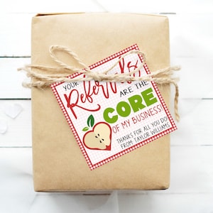 May include: A red and white gingham gift tag with a green apple graphic and the text "You're the core of my business! Thanks for all you do! From Taylor Williams."