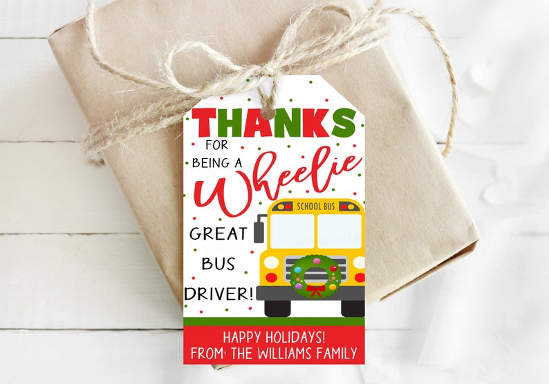 May include: A gift tag with the text "THANKS FOR BEING A Wheelie GREAT BUS DRIVER!" in red and green. A yellow school bus graphic is featured. The tag is tied to a wrapped gift with twine.