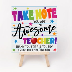 May include: A colorful sign with the text "TAKE NOTE YOU ARE ONE AWESOME TEACHER!" with a red apple and stars. The sign is on a small wooden easel. The text "THANK YOU FOR ALL YOU DO! FROM: THE LAKESIDE PTO" is at the bottom of the sign.