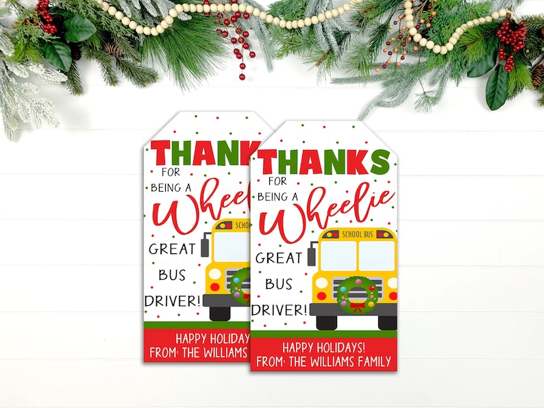 May include: Two gift tags with a school bus design. The tags read "THANKS for being a Wheelie GREAT BUS DRIVER!" in red and green. The bottom of the tags say "HAPPY HOLIDAY FROM THE WILLIAMS FAMILY".