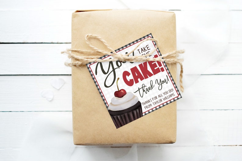 May include: A brown gift box with a black and white checkered gift tag that says "You Take the Cake! Thank You! Thanks for all you do! From Taylor Williams". The tag has a red and white cupcake with a cherry on top.