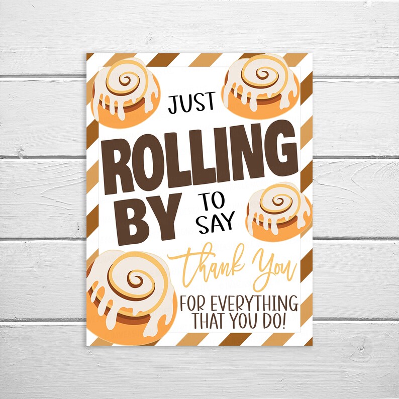 May include: A white sign with brown stripes and a message that says "Just rolling by to say thank you for everything that you do!" with images of cinnamon rolls.