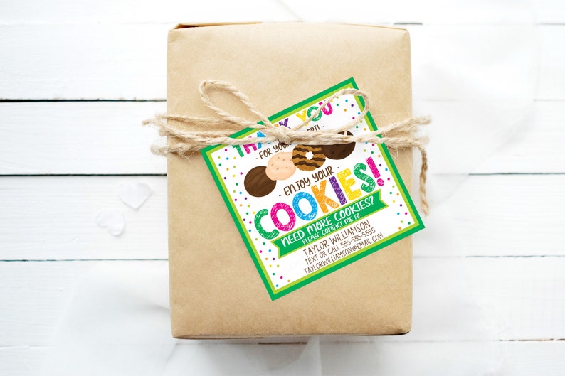 May include: A wrapped gift in brown paper tied with twine, featuring a colorful tag. The tag reads "Thank you - Enjoy your cookies!" with cookie illustrations and contact information for Taylor Williamson.