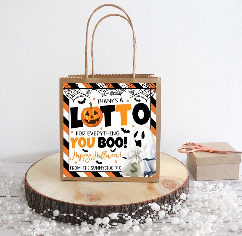 May include: A brown paper gift bag with a Halloween-themed design. The bag features a pumpkin, ghost, and the text "THANKS A LOTTO FOR EVERYTHING YOU BOO! Happy Halloween!" The bag has brown paper handles.