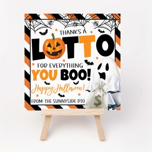 May include: A Halloween-themed sign with orange and black stripes, a jack-o'-lantern, and a ghost holding a money bag. Text reads "THANKS A LOTTO FOR EVERYTHING YOU BOO! Happy Halloween!" and "FROM: THE SUNNYSIDE PTO."