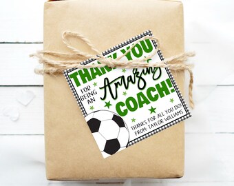 May include: A white gift tag with green and black checkered border. The tag says "Thank You for being an Amazing Coach!" with a football graphic and the text "Thanks for all you do! From Taylor Williams".