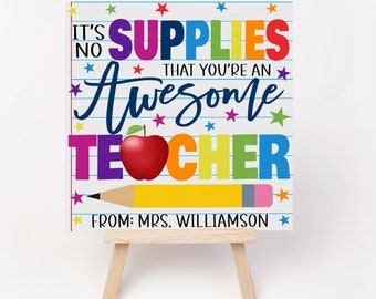 Puede incluir: No son los materiales los que te hacen un profesor increíble, de parte de la Sra. Williamson. Un cartel colorido con una manzana roja y un lápiz amarillo en un caballete de madera.