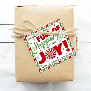 K&ouml;nnte beinhalten: Ein wei&szlig;er Geschenkanh&auml;nger mit roten und gr&uuml;nen Streifen. Der Anh&auml;nger hat ein rotes und wei&szlig;es Zuckerstangen-Design und den Text "Wishing you a season full of happiness and joy! From: The Sunnyside School PTO".