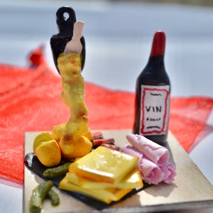 Miniatyr raclettetallrik med potatis, ost, charkuterier, gurkor och vin, dekorativt föremål, handgjort av Fimo-polymerlera