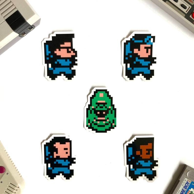May include: Five pixel art stickers featuring characters from the video game Contra. The stickers are on a white background. The characters are in blue, green, and brown.