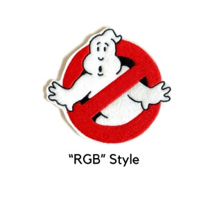 May include: Red and white embroidered patch featuring the Ghostbusters "No Ghost" logo. The logo is a red circle with a diagonal line through it and a white ghost figure in the center. The text "RGB" Style is below the logo.