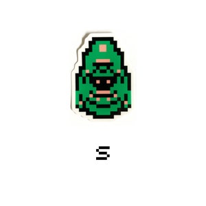 May include: Green pixel art sticker of a creature with a pink hat and black eyes. The sticker is on a white background.