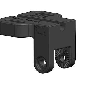 May include: A black, angular mechanical component with the text "RIPCORD OUTLAW" and "HELIX F MEGA" printed on it. The component has a stylized bull logo and a circular gear-like feature.