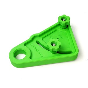 May include: Green plastic jig with two knobs and a hole. The jig is labelled "YAK HOBBY" and "7202".