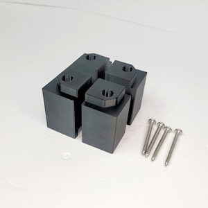 May include: Four black plastic corner brackets with screw holes and four silver screws.
