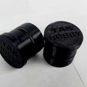 Puede incluir: Dos contenedores de plástico negro con las palabras "YAK HOBBY" impresas en la parte superior.
