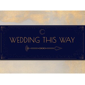 May include: A navy blue sign with gold text that reads "WEDDING THIS WAY." The sign has an art deco design with an arrow pointing right. The background is a gold and white marbled pattern.