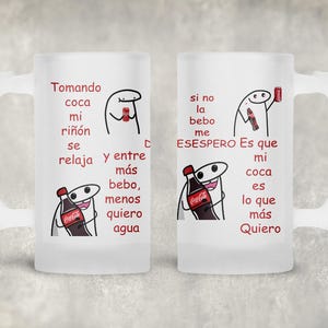 Może przedstawiać: Dwa białe ceramiczne kubki z humorystyczną ilustracją postaci z kreskówek pijącej Coca-Colę. Tekst na kubkach brzmi "Tomando coca mi riñón se relaja y entre más bebo, menos quiero agua" i "Si no la bebo me ESESPERO Es que mi coca es lo que más Quiero".