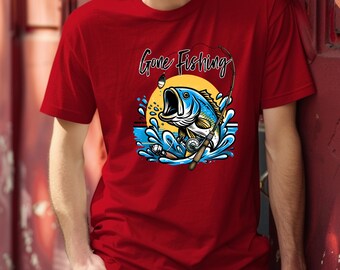 May include: Red t-shirt with a graphic of a blue and yellow fish jumping out of the water, a fishing rod, and the words "Gone Fishing". The design is set against a yellow sun and blue water.