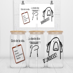 May include: Three clear glass tumblers with bamboo lids and black and white illustrations. The illustrations depict a stick figure with a thought bubble that says "¿a donde dice "TRABAJAR"?" and a stick figure with an open mouth and the text "DONDEEE!" or "D'JNDEEE!" The tumblers also have a black and white checklist that says "Ciclo de la vida:" with the items "Naces", "Creces", "Te reproduces", and "Mueres".