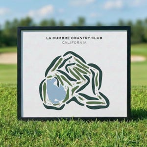 May include: Framed artwork of the La Cumbre Country Club in California. The golf course map features green fairways, a blue water hazard, and the club's name and location in black text on a white background. The frame is black.