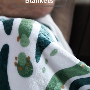 a person laying down on a couch with a blanket