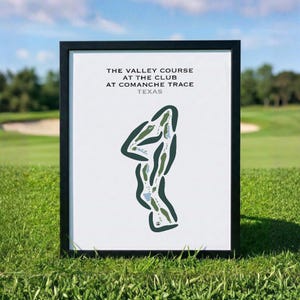 May include: A framed print featuring a minimalist map of The Valley Course at The Club at Comanche Trace, Texas. The design displays the golf course layout in dark green with light blue water hazards on a white background, enclosed in a black frame.
