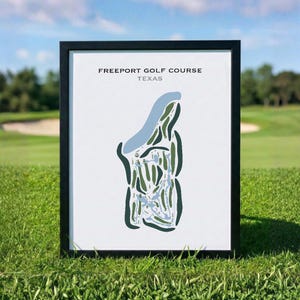 May include: A framed print featuring a minimalist map of the Freeport Golf Course in Texas. The design uses dark green for the fairways, light blue for water hazards, and white for the background, all enclosed in a simple black frame.