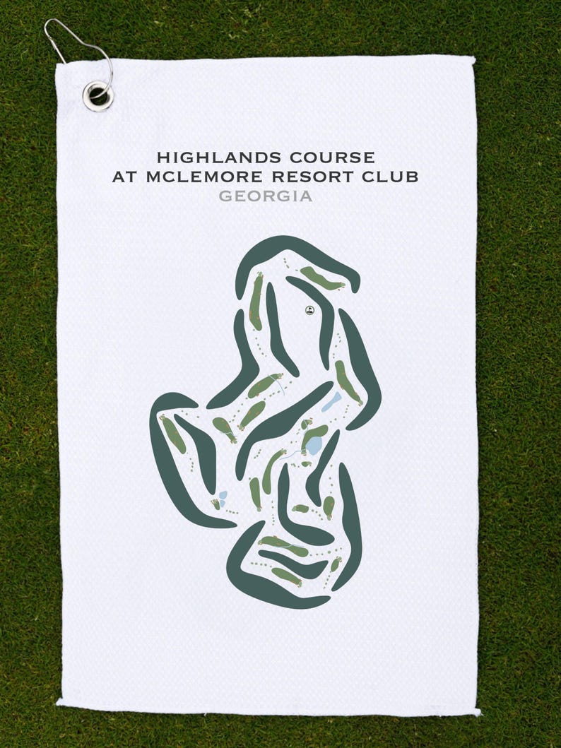 May include: White golf towel featuring a course map of the Highlands Course at McLemore Resort Club, Georgia. The map is in green and blue hues, showing the course layout. The towel has a metal grommet and hook.