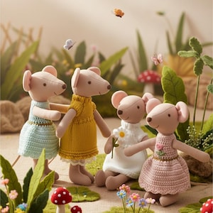 Puede incluir: Cuatro muñecas de ratón de peluche en un jardín caprichoso. Cada ratón viste un vestido de color pastel diferente: azul claro, amarillo, blanco y rosa. Mariposas y setas en miniatura se suman al tema de cuento de hadas.