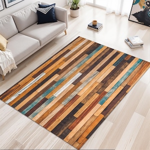 Op de afbeelding: Een rechthoekig vloerkleed met een ontwerp van houten planken. Het vloerkleed heeft een verscheidenheid aan houttinten, waaronder bruin, beige en blauw. De planken zijn in een horizontaal patroon gerangschikt.