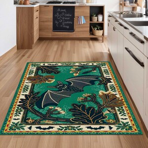 May include: A green and brown area rug with a black bat design and a white border. The rug has a repeating pattern of bats, leaves, and acorns.