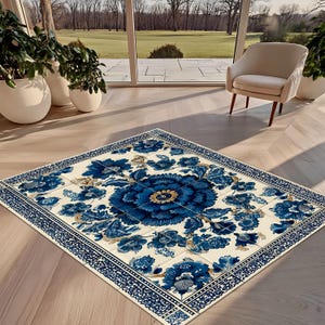 May include: A rectangular area rug featuring a cream-colored background with a large, central dark blue floral medallion. The design includes intricate blue floral patterns throughout, surrounded by a decorative blue and white geometric border.