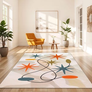 Puede incluir: Una alfombra blanca con un diseño abstracto moderno que presenta estrellas, círculos y líneas de colores. La alfombra tiene un fondo crema con acentos naranja, azul, verde y amarillo.