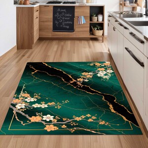 Può includere: Tappeto verde e oro con un motivo a marmi e un design floreale. Il tappeto ha un bordo nero.