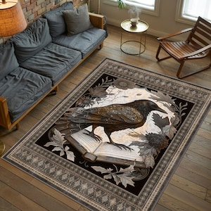 May include: A black and white area rug with a dark raven perched on an open book. The rug has a detailed floral design and a black background with a decorative border.