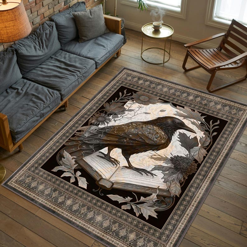 May include: A black and white area rug with a dark raven perched on an open book. The rug has a detailed floral design and a black background with a decorative border.