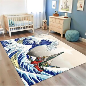 Könnte beinhalten: Rechteckiger Teppich mit einer stilisierten Darstellung einer großen Ozeanwelle mit einem Boot und Figuren. Das Design des Teppichs verwendet Blau-, Weiß- und Beigetöne und schafft eine dynamische und künstlerische Ästhetik. Der Teppich befindet sich in einem Kinderzimmer.