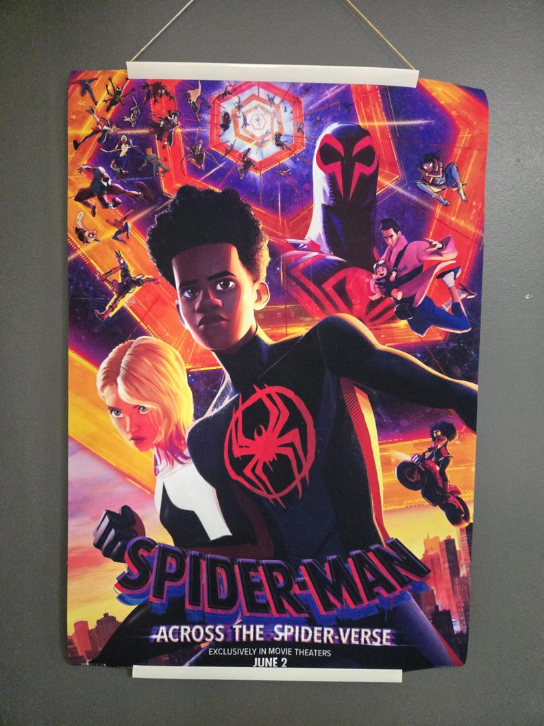 May include: A colorful poster for the movie "Spider-Man: Across the Spider-Verse" featuring Miles Morales and Gwen Stacy. The poster has a red spider symbol and the movie title. The release date is June 2.