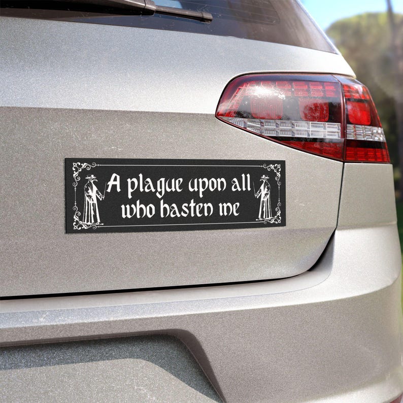 May include: A rectangular black bumper sticker with a white border and decorative corner flourishes. The text reads A plague upon all who hasten me, flanked by two white illustrations of plague doctors in long coats and bird-like masks.