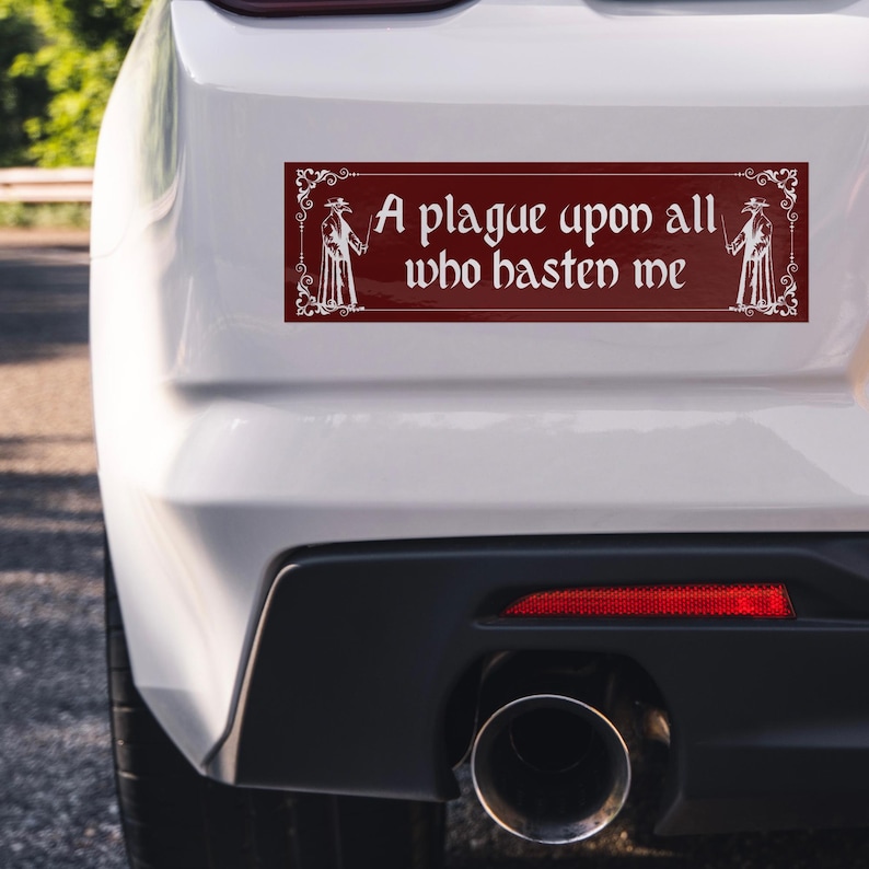 May include: A rectangular bumper sticker with a deep red background and white decorative border. It features white illustrations of plague doctors on both sides and the text A plague upon all who hasten me in a gothic font style.