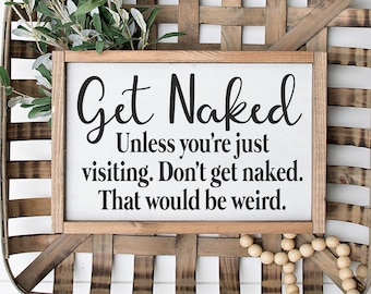 May include: A wooden sign with the text "Get Naked Unless you're just visiting. Don't get naked. That would be weird." The sign is sitting in a woven basket with a strand of wooden beads.
