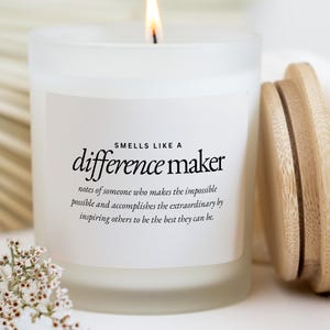 May include: A white ceramic mug with a black handle and the text "But First, Coffee" in a black, handwritten-style font. The mug is on a white surface.